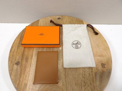 un petit plateau en bois sur lequel sont posés un portefeuille et un étui à cartes