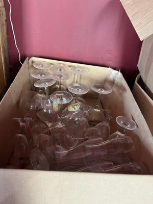 une boîte de verres à vin vides posée par terre