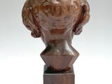 sculpture of a woman ' s head on a wooden base