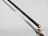 an old sword with a wooden handle on a white surface