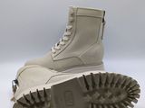 a close up of a pair of white boots on a white surface