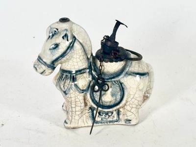 figurine en porcelaine représentant un cheval blanc avec une selle sur le dos