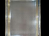 an antique silver plated mirror with a gold border