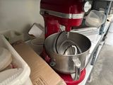 a red mixer sitting on a kitchen counter next to a box