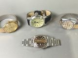 three watches and a wrist watch are sitting on a table