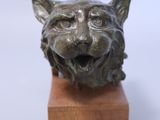 a small statue of a cat on a wooden block