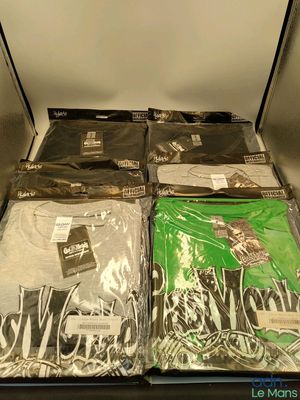 a lot of t - shirts that are sitting on a shelf