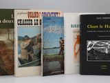 trois livres sont empilés sur une surface blanche