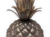 an image of a metal pineapple sitting on top of a white surface