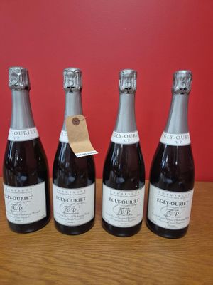 quatre bouteilles de vin sont alignées sur une table en bois