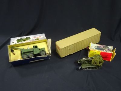 two toy military vehicles are sitting in a box on a black surface