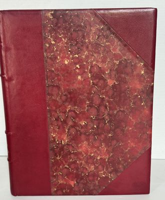 un livre rouge orné de dorures, posé sur une table