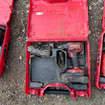 three tools in a red case sitting on the ground next to each other