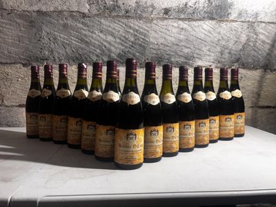 bottles of wine are lined up on a table in front of a brick wall