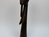 a wooden figurine of a woman wearing a headdress