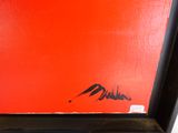une peinture représentant une boîte rouge sur laquelle figure une inscription en noir