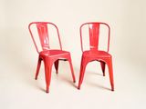 deux chaises rouges placées l'une à côté de l'autre sur une surface blanche