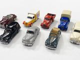 several toy cars are lined up in a row on a white surface