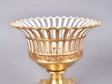 gold plated bowl on stand on grey background with white background