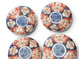 four blue and white plates with red flowers on them