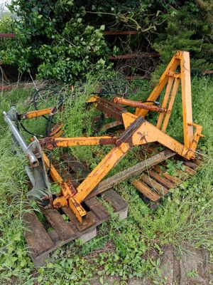 un tracteur qui est garé dans l'herbe, près d'une clôture