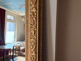 a large gold mirror in the corner of a room