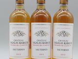 trois bouteilles de vin posées les unes à côté des autres sur une surface blanche