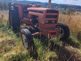 a red tractor that is sitting in the grass