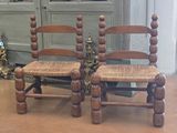 two wooden chairs sitting next to each other on the floor