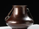 a brown vase sitting on top of a white table