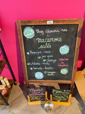 a chalk board with a menu on it in front of a pink wall