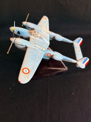 un petit avion en jouet posé sur une surface noire