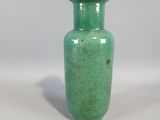 a small green vase sitting on a white surface