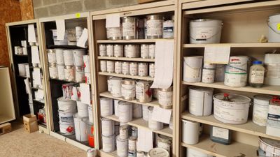 several shelves with paint and other paint products on them