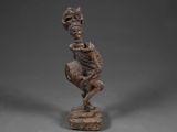 une statue en bronze représentant un homme avec un crâne sur la tête