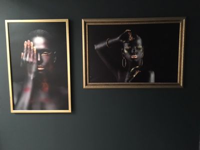 two pictures hanging on the wall above a toilet