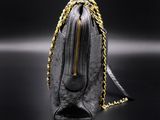 a black purse with a gold chain hanging from it