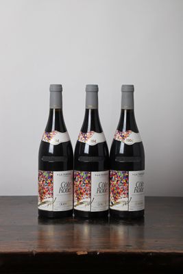 trois bouteilles de vin posées sur une table en bois