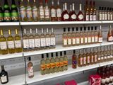 bottles of alcohol are on a shelf in a liquor store
