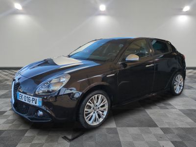 a black alfa car parked on a checkered floor in a garage