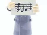 une figurine représentant un homme tenant une pancarte sur laquelle figurent des notes de musique