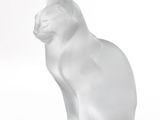 a white cat statue sitting on a white surface