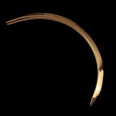 a close up of a gold bracelet on a black background
