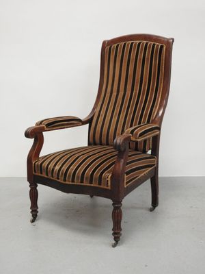 une chaise rayée de marron et de noir posée sur un sol en béton
