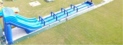 a blue water slide in the middle of a green field