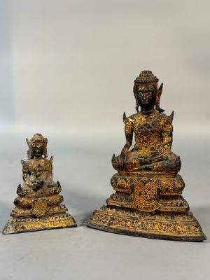 two statues of buddhas sitting on top of a white surface