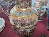 many vases and plates on a table with a red table cloth