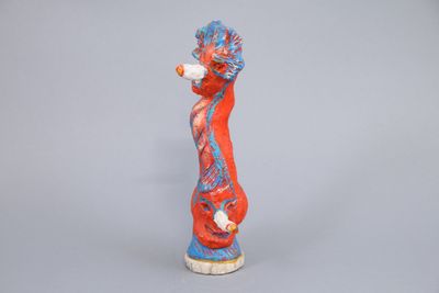 figurine of a red and blue seahorse holding a bottle of wine