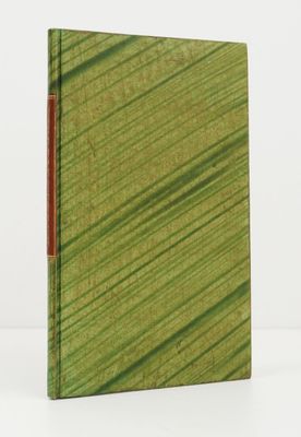 un livre à la couverture verte posé sur une table blanche