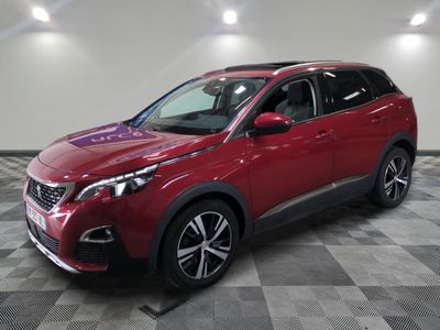 une voiture rouge est garée dans une pièce au sol en damier